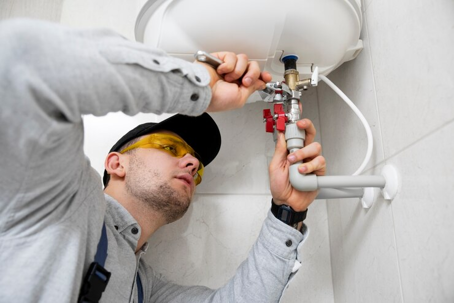 plumber working under sink
